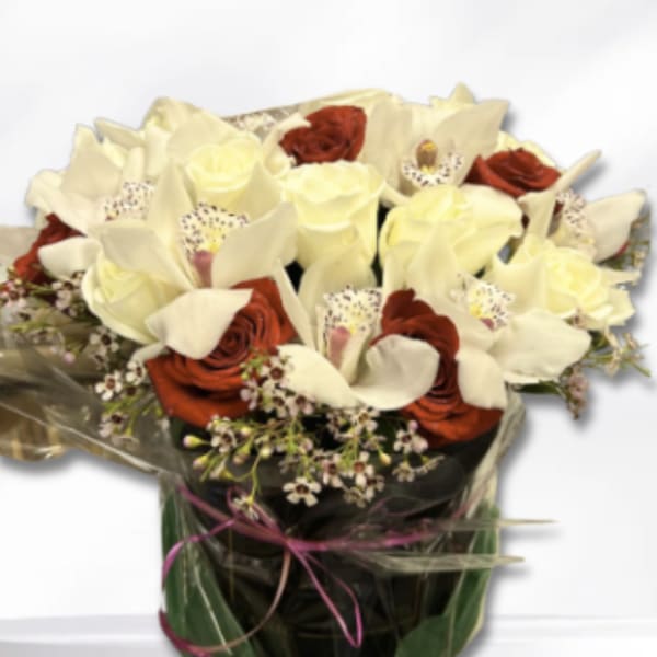 Bouquet of cream calla lilies and red roses wrapped in dark paper