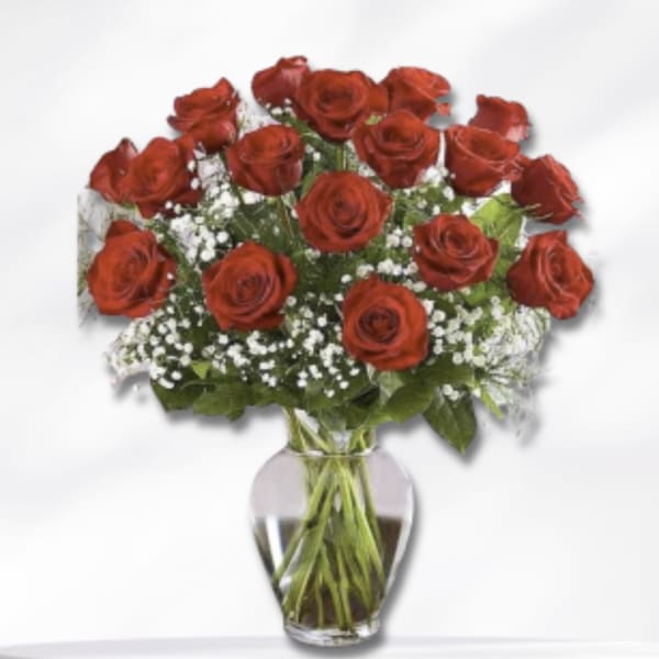 Bouquet of red roses and baby's breath in a clear glass vase