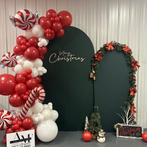 Christmas balloon display with a green backdrop and wreath