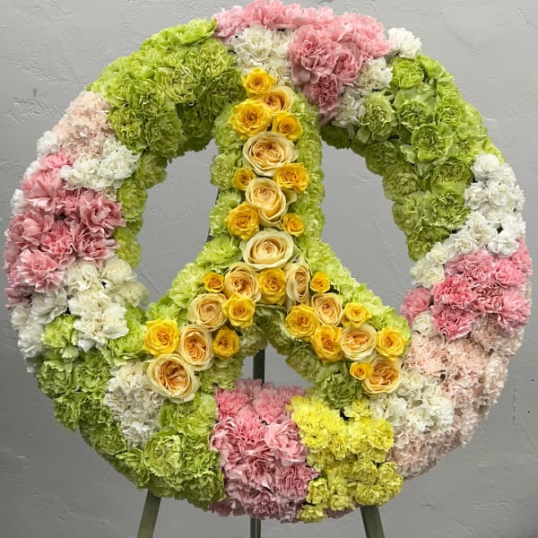 Large floral peace sign made of pink, green, white, and yellow flowers