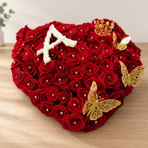Heart-shaped arrangement of red roses with gold butterfly accents