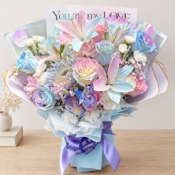 Pastel bouquet of roses and lilies with a purple ribbon and butterfly accents