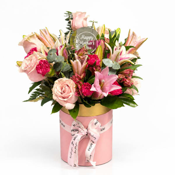 Pink and white flower arrangement in a pink hat box with a Mother's Day sign