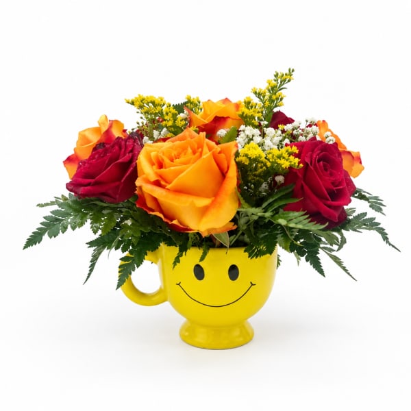 Yellow smiley-face mug holding red and orange roses