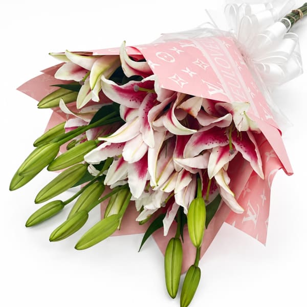 Bouquet of pink-and-white lilies wrapped in pink paper
