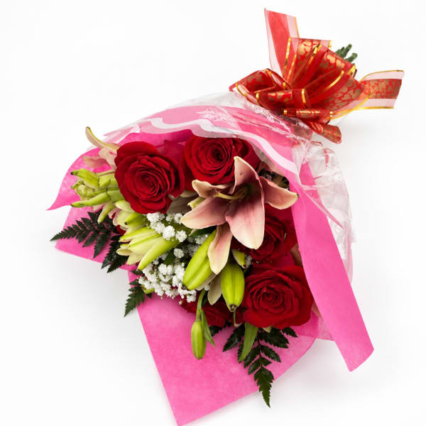Bouquet of red roses and pink lilies wrapped in pink paper