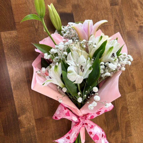 Pink and white bouquet with lilies and baby's breath wrapped in pink paper