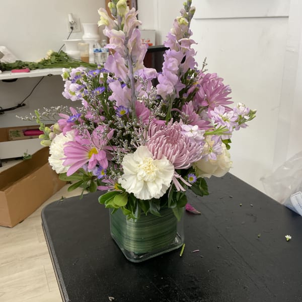Pink and white mixed bouquet in a square glass vase