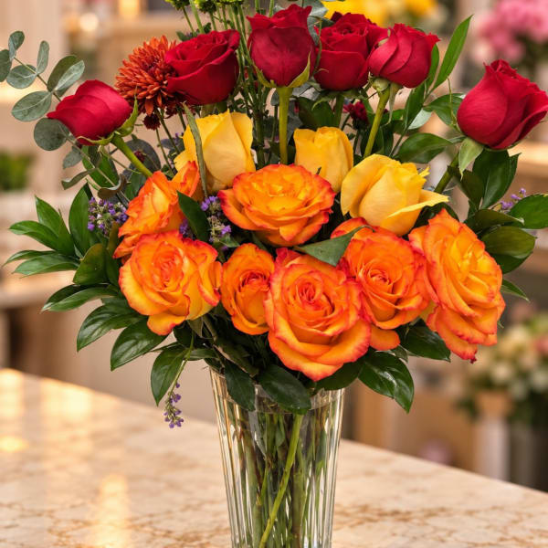Bouquet of red and orange roses in a clear glass vase