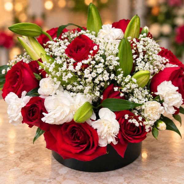 Red roses and white carnations in a black round box