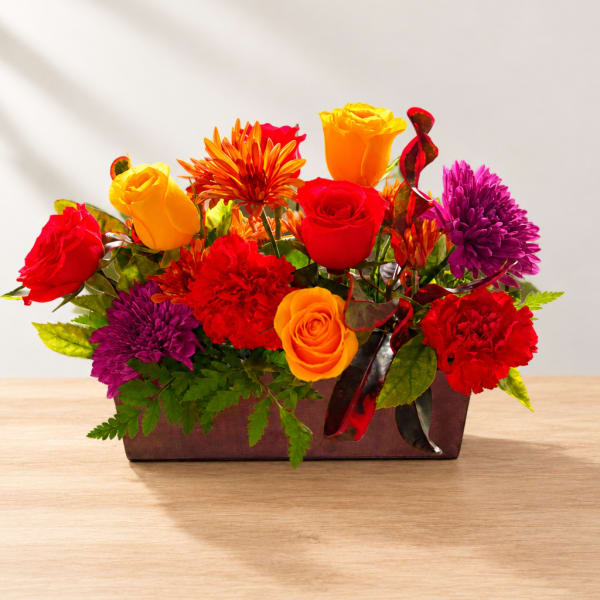 Colorful mixed flower arrangement in a rectangular vase