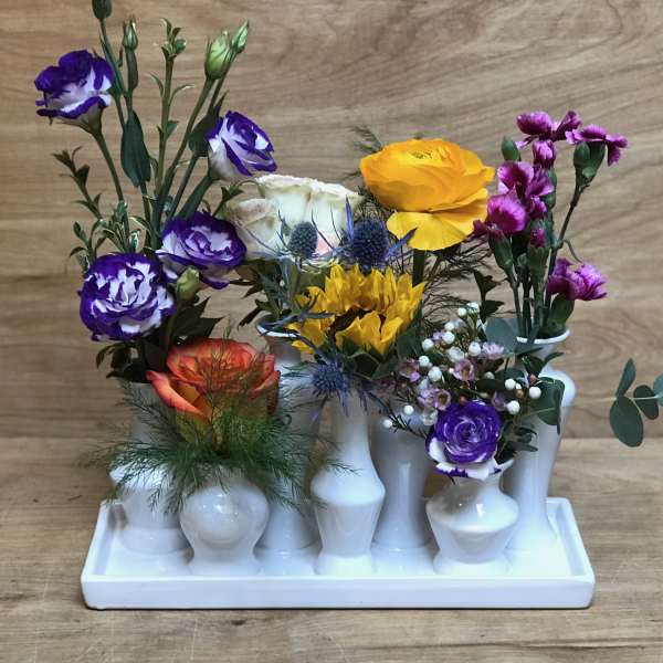 Mixed bouquet in white bud vases on a tray