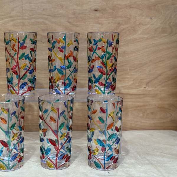 Six clear glass tumblers with colorful leaf patterns