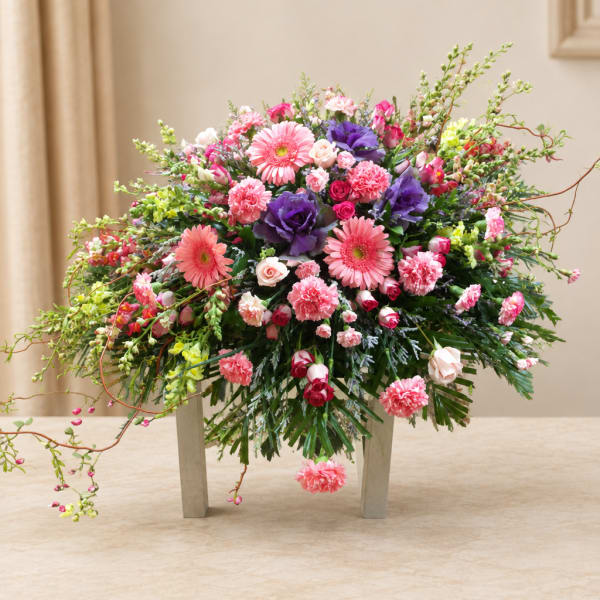 Mixed pink and purple flower arrangement in a low container
