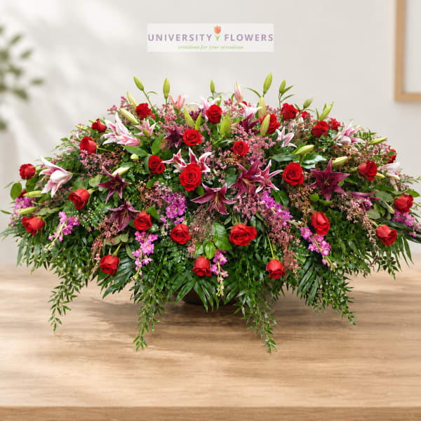 Large mixed bouquet of red roses and pink lilies in a low container