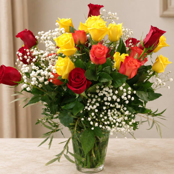 Bouquet of red and yellow roses in a clear glass vase