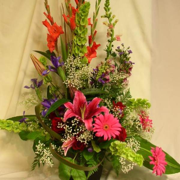 Tall mixed flower arrangement with pink lilies and gerbera daisies in a vase