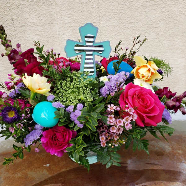 Colorful floral arrangement with a turquoise cross centerpiece