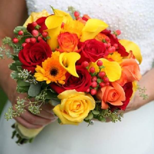 Bouquet of red and yellow roses with orange flowers and berries