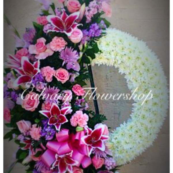 Pink and purple floral standing wreath with a large white heart shape