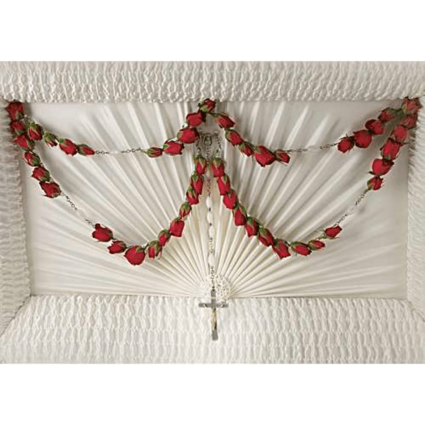 White fan-shaped funeral spray with red rose garlands and a cross pendant