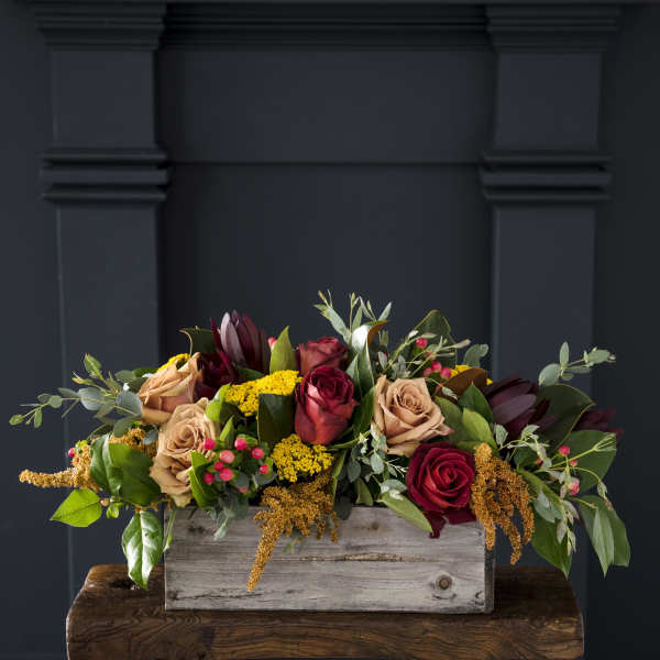 Mixed roses in a rustic wooden box with greenery and yellow filler flowers