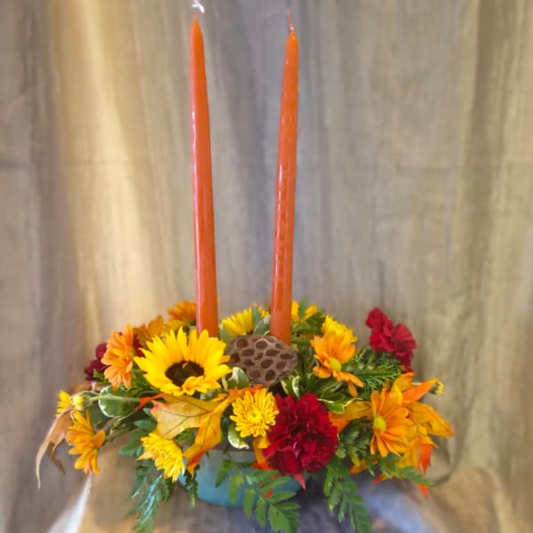 Autumn floral centerpiece with two orange taper candles
