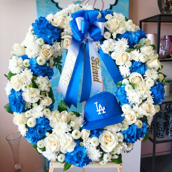 Blue and white floral wreath with ribbons and a baseball cap