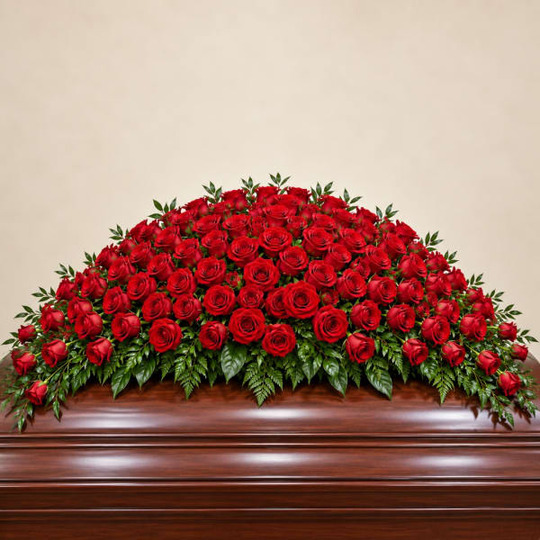 Large red rose casket spray on a wooden casket