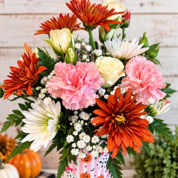 Bouquet of orange, pink, and white flowers in a striped container