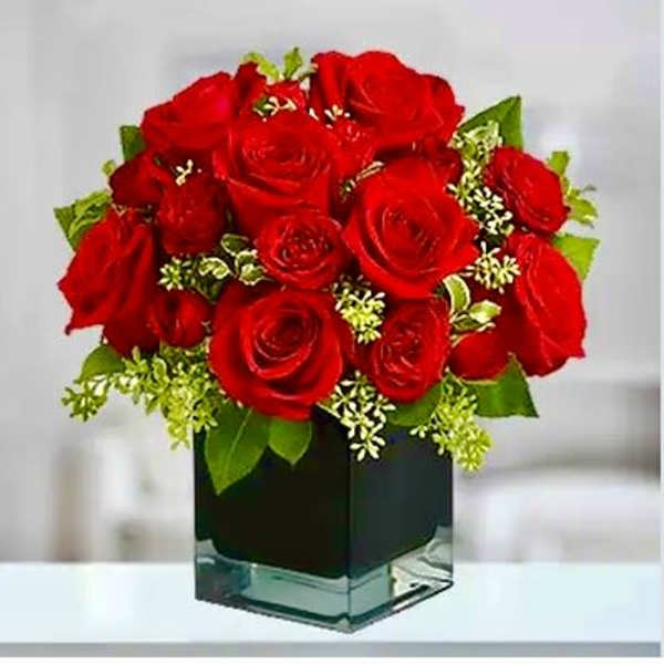 Red roses arranged in a square glass vase