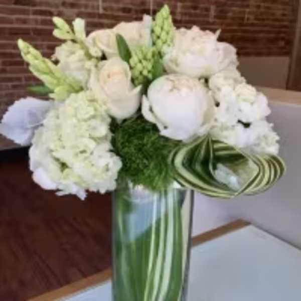 White floral arrangement in a tall glass vase