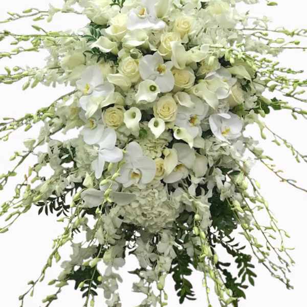 Large cascading white spray with roses, orchids, calla lilies, and hydrangeas