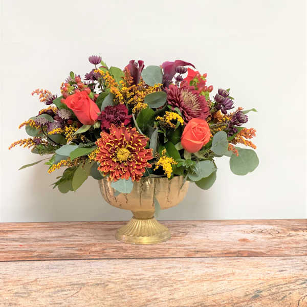 Mixed bouquet in a gold pedestal vase with roses and chrysanthemums