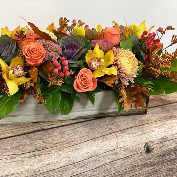 Autumn floral arrangement in a rectangular wooden box with roses and orchids