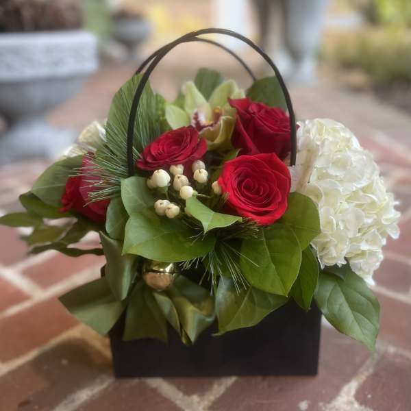 Basket arrangement with red roses and white hydrangea