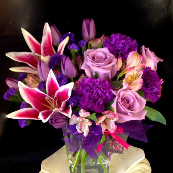 Purple and pink mixed bouquet in a clear glass vase