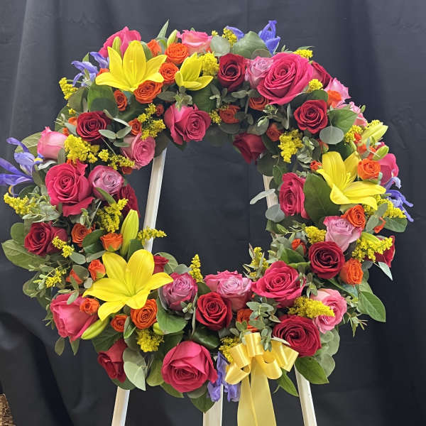 Colorful floral wreath on a stand with roses and lilies