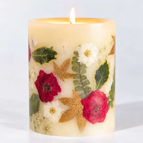 Floral-decorated pillar candle with a lit flame