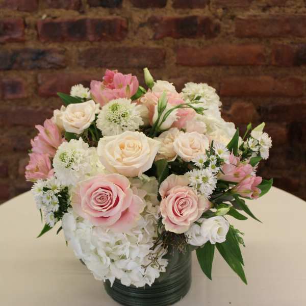 Pink and white roses with hydrangeas in a dark vase