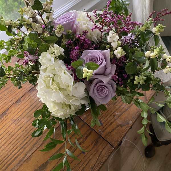 Lavender roses and white hydrangeas in a loose bouquet with berry branches
