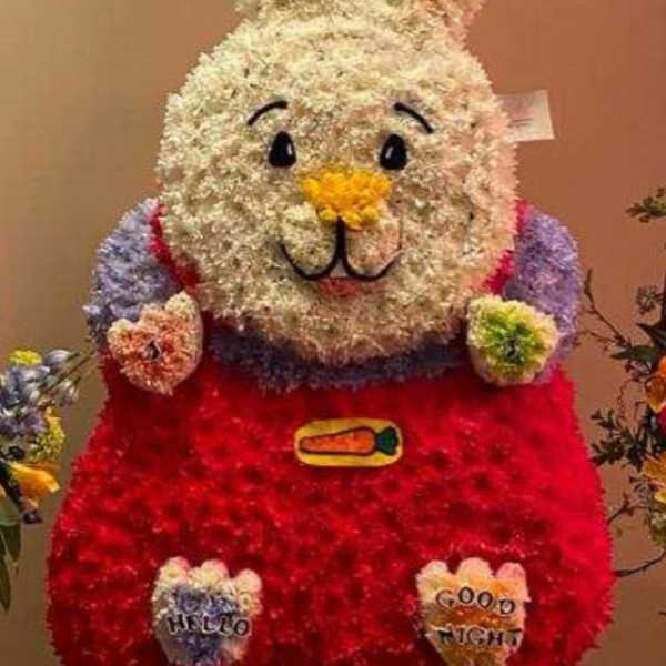 Flower-covered bunny figure with balloons above it