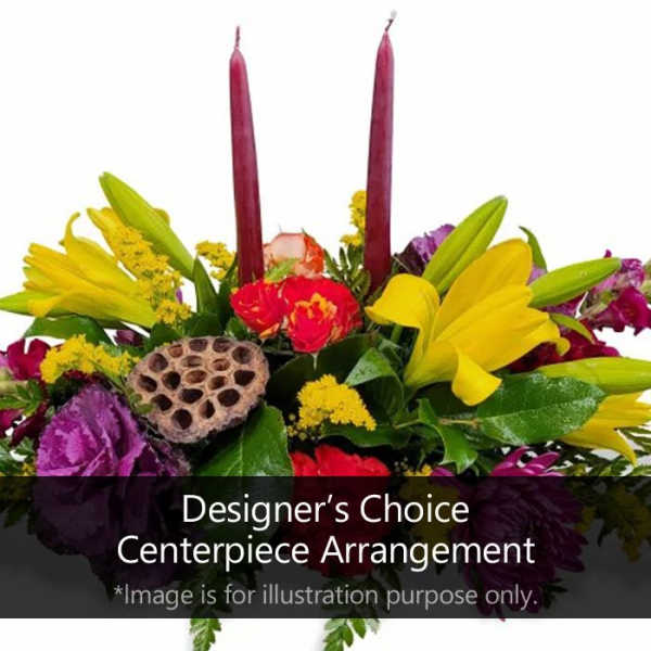 Colorful floral centerpiece with tall candles and a lotus pod