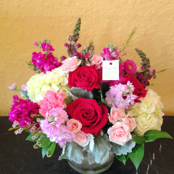 Bouquet of red and pink roses with hydrangeas in a glass vase