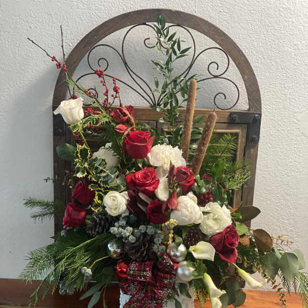 Holiday floral arrangement with red and white roses in a decorative basket