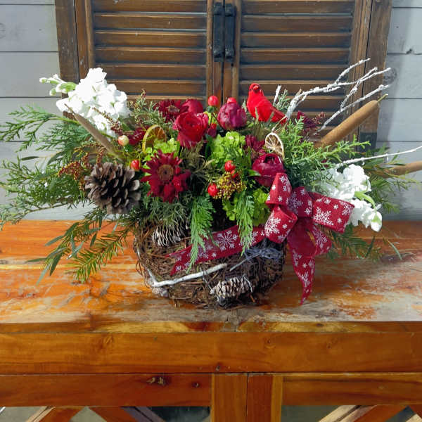 Holiday floral arrangement with red and white flowers in a basket