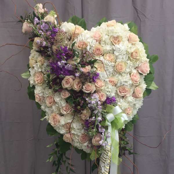 Heart-shaped floral standing spray with pink roses and white blooms