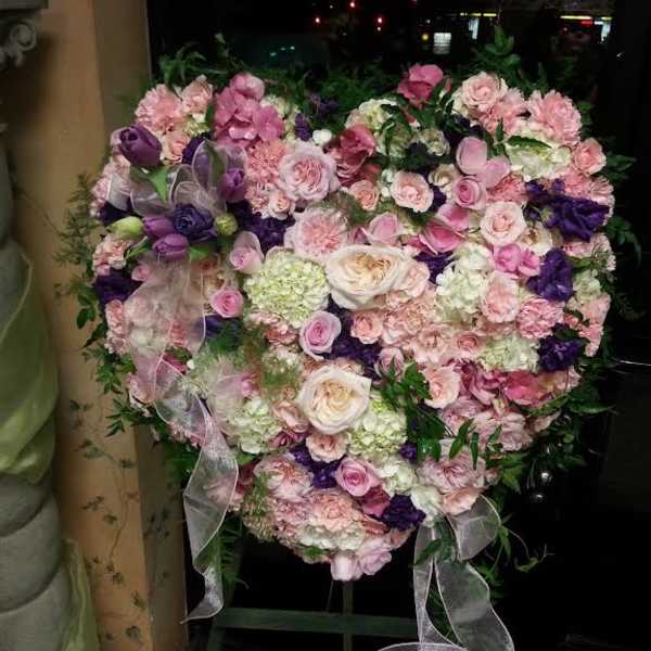 Heart-shaped floral arrangement in pink, white, and purple tones