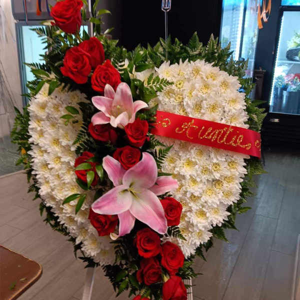 Heart-shaped floral wreath with red roses, white chrysanthemums, and pink lilies