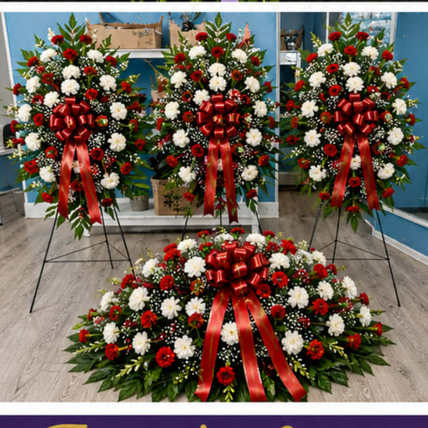 Three red and white floral standing sprays with red bows and a matching floor arrangement